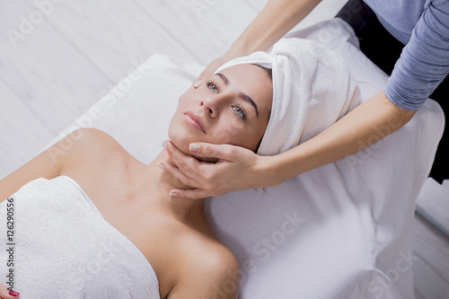 Young woman enjoying facial massage at spa salon.Facial massage