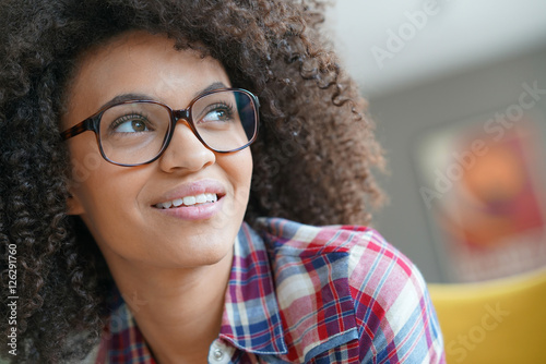 Portrait of mixed-race girl with eyeglasses looking on one side