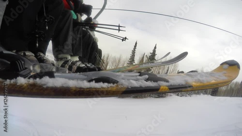 Low shot of skiers on the ski lift going up mountain