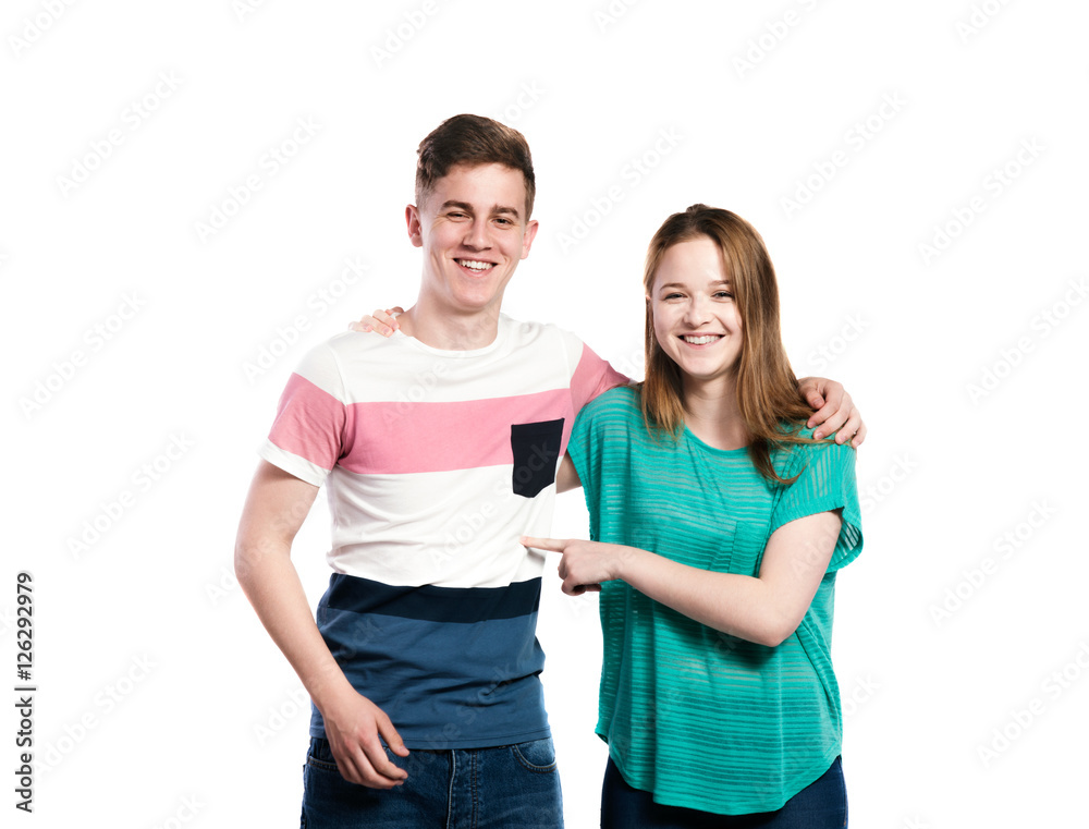 Teenage boy and girl, arms around each other, isolated. Teenage boy and girl, arms around each other, isolated.