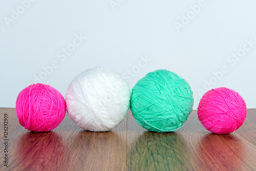 Bright balls of acrylic yarn on a wooden table. Needlework. Knit and Crochet. Fashion trends.