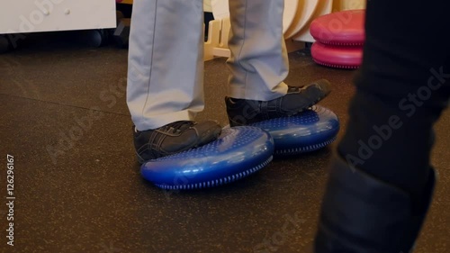Man practices balance in physical therapy dolly shot