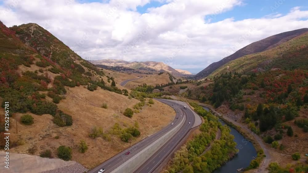 Aerial shot cars travel on mountain highway with fall colors Aerial shot cars travel on mountain highway with fall colors