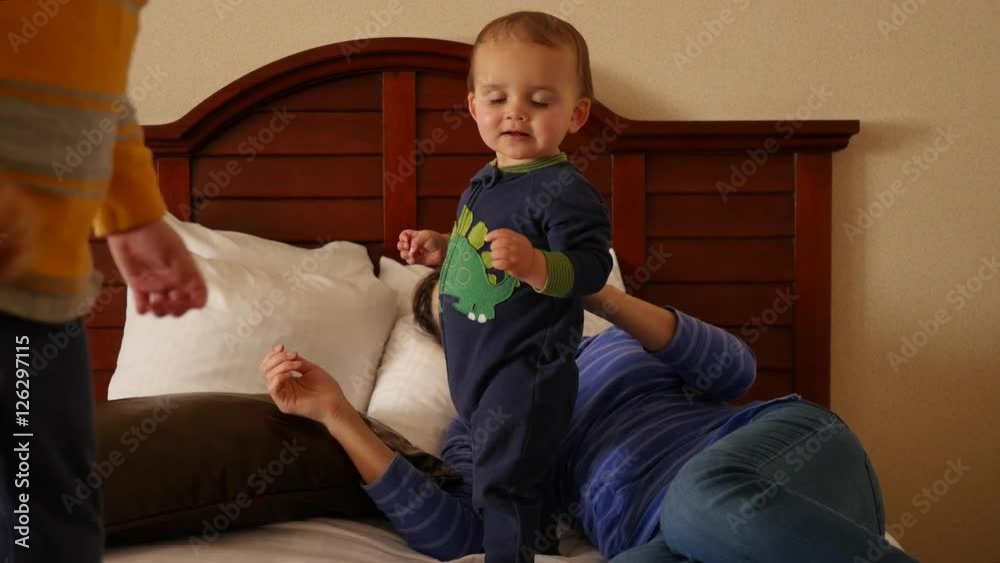 An interior dolly shot of a family on hotel room bed An interior dolly shot of a family on hotel room bed