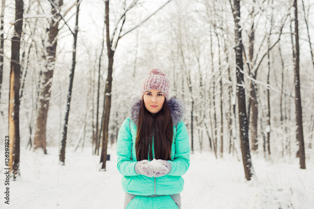 Girl in winter snowy park. Snow, cold and seasonal concept Girl in winter snowy park. Snow, cold and seasonal concept
