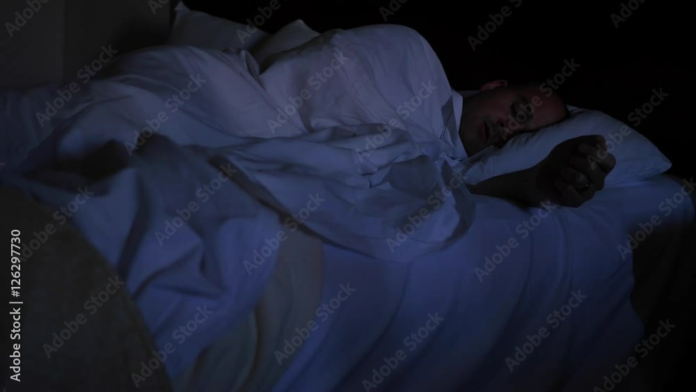 A man sleeping in a hotel bed