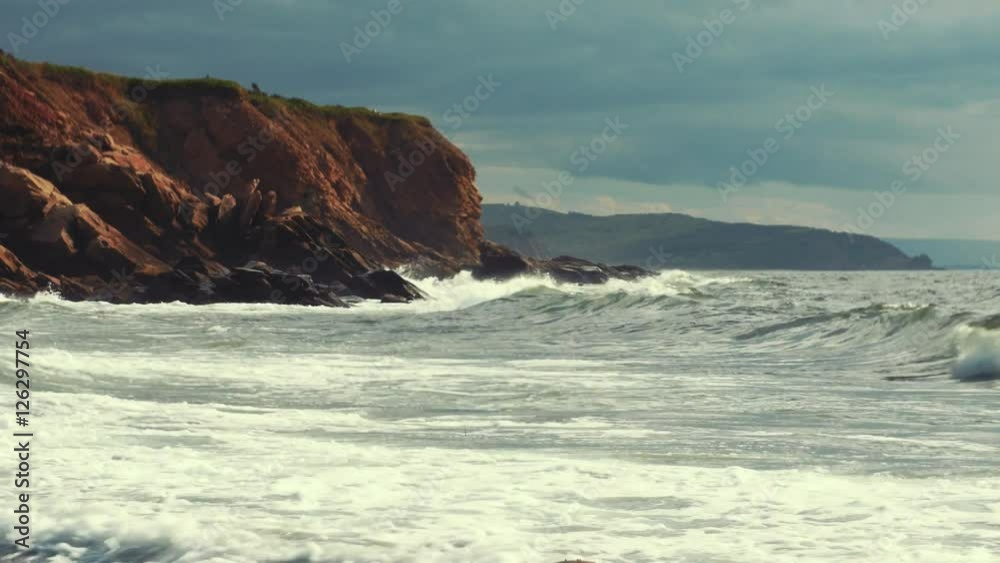 Waves crash on gorgeous rocky ocean coastline with cliffs Waves crash on gorgeous rocky ocean coastline with cliffs