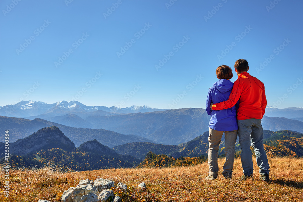 active hikers hiking enjoying view looking at mountain landscape
