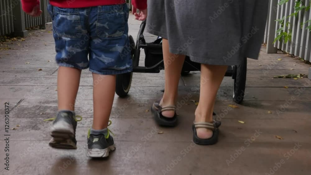 Mother and boy pushing stroller gimbal shot Mother and boy pushing stroller gimbal shot