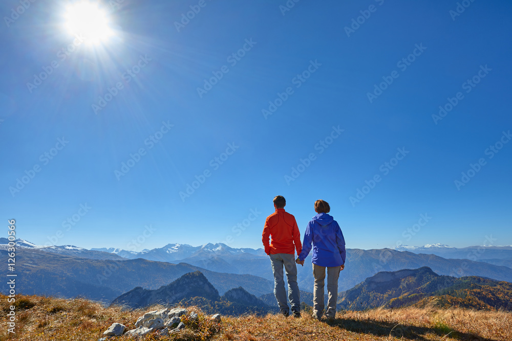 active hikers hiking enjoying view looking at mountain landscape
