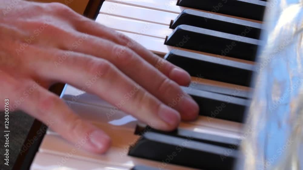 Fingers playing keys of a beautiful black grand piano Fingers playing keys of a beautiful black grand piano