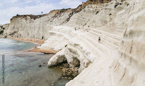 Unidentified peoplel goes on a slope of white cliff called 