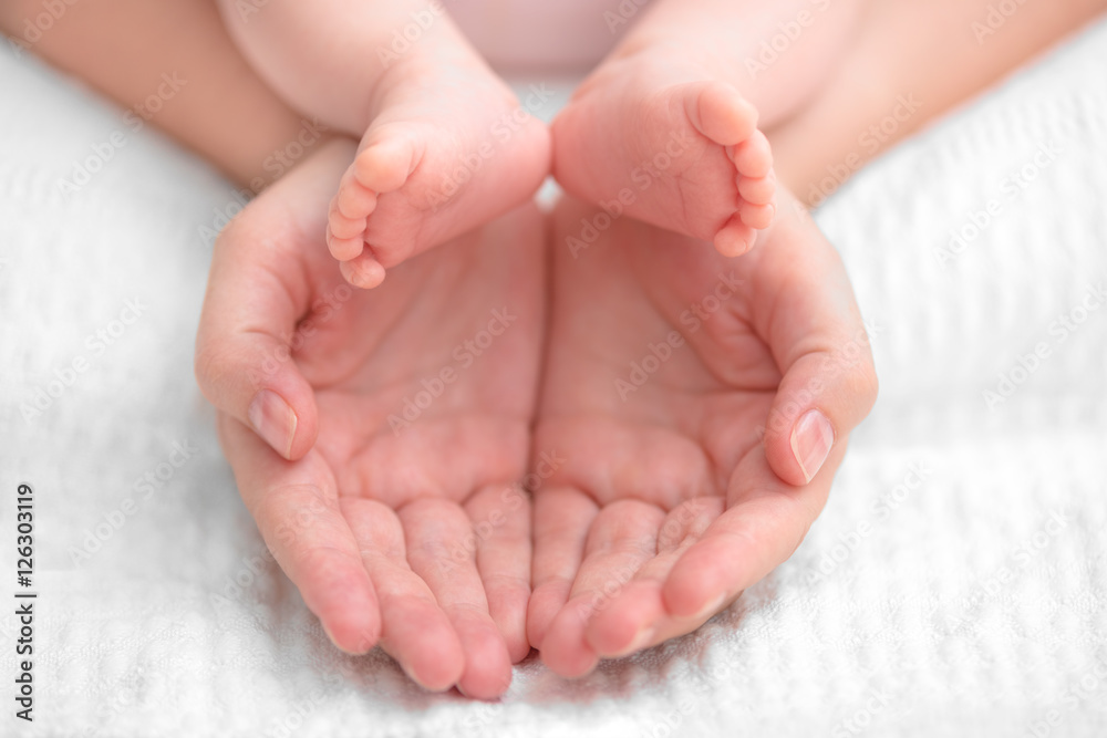Close-up of mother hands holding tiny baby feet Close-up of mother hands holding tiny baby feet