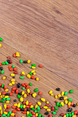 Colorful candy scattered on the wooden table.