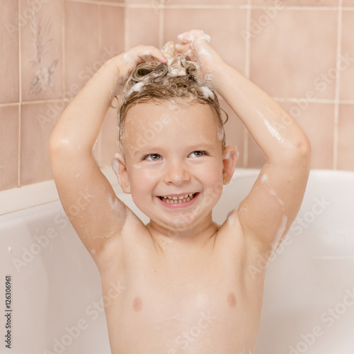 Cute little girl washes her hair