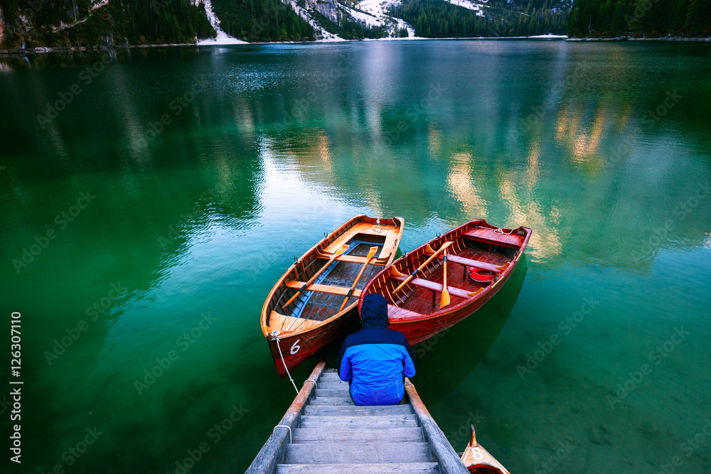 Man alone at the Braies Lake ( Pragser Wildsee ) in Dolomites mo
