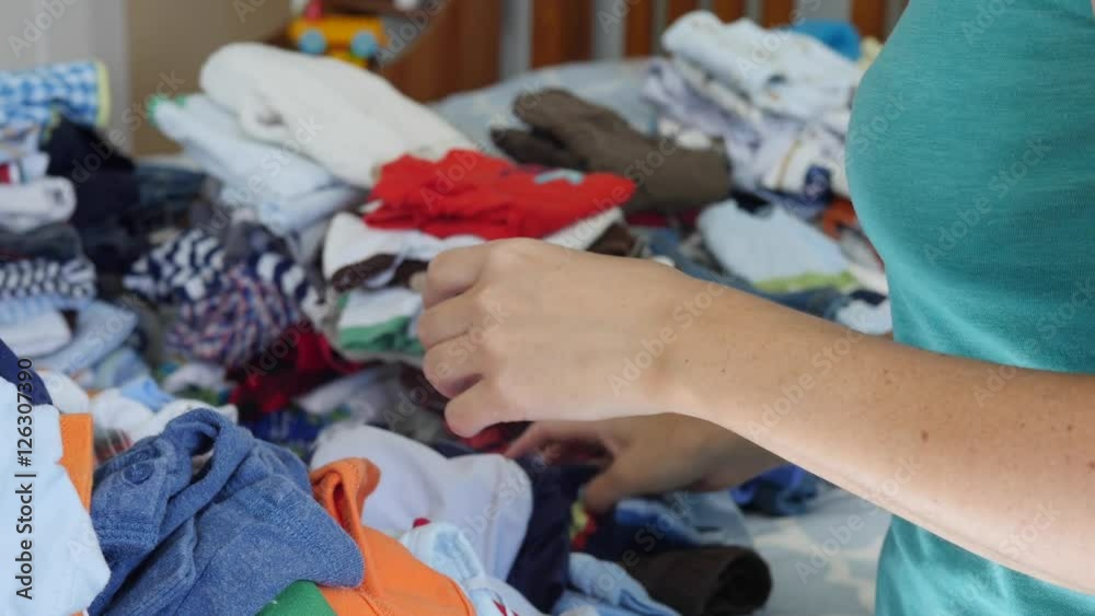 A young mother sorting through the kids clothes