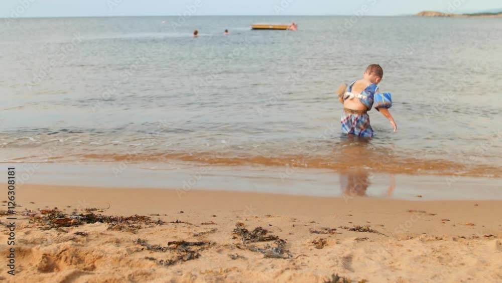 Little boy in ocean at beautiful beach in the sand Little boy in ocean at beautiful beach in the sand