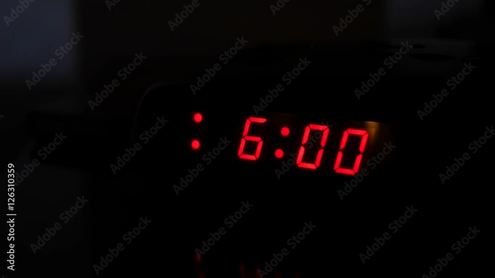 Man turns off alarm clock and turns on light