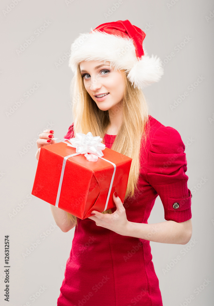 Young woman in a Christmas hat holding a present Young woman in a Christmas hat holding a present