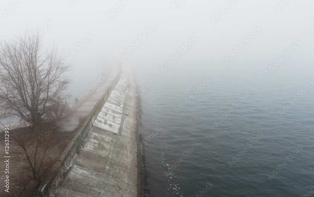 concrete dam pier in the mist in autumn day