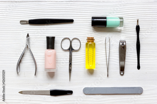nail polish, cuticle oil and manicure set on wooden background