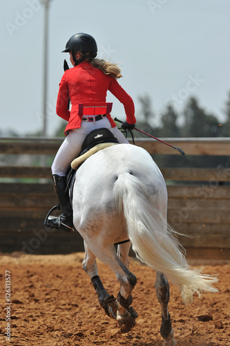 The rear view of a rider on a horseback running ahead