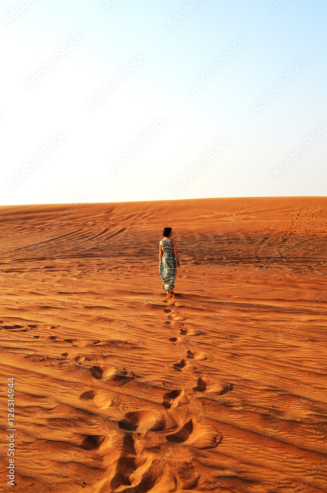 Fototapeta premium silhouette of a girl in the setting sun in the desert in the Uni