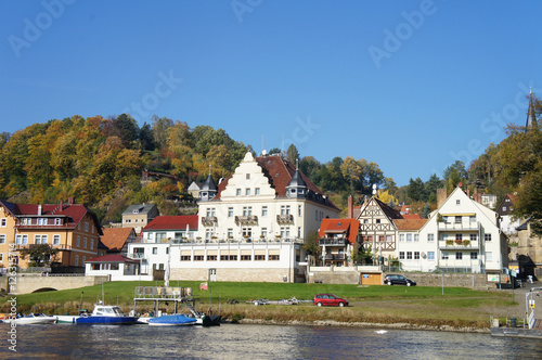 Kurort an der Elbe/Idyllischer Kurort an der Elbe in der Sächsischen Schweiz in Deutschland, schöne Häuser und bunte Laubwälder, im Vordergrund die Elbe, 