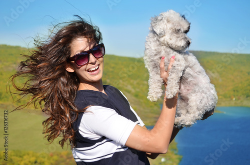 Obraz na płótnie smiling woman hugging  her small havanese dog outdoor