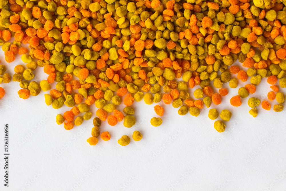 Pollen of different colors is scattered on white background. Stock