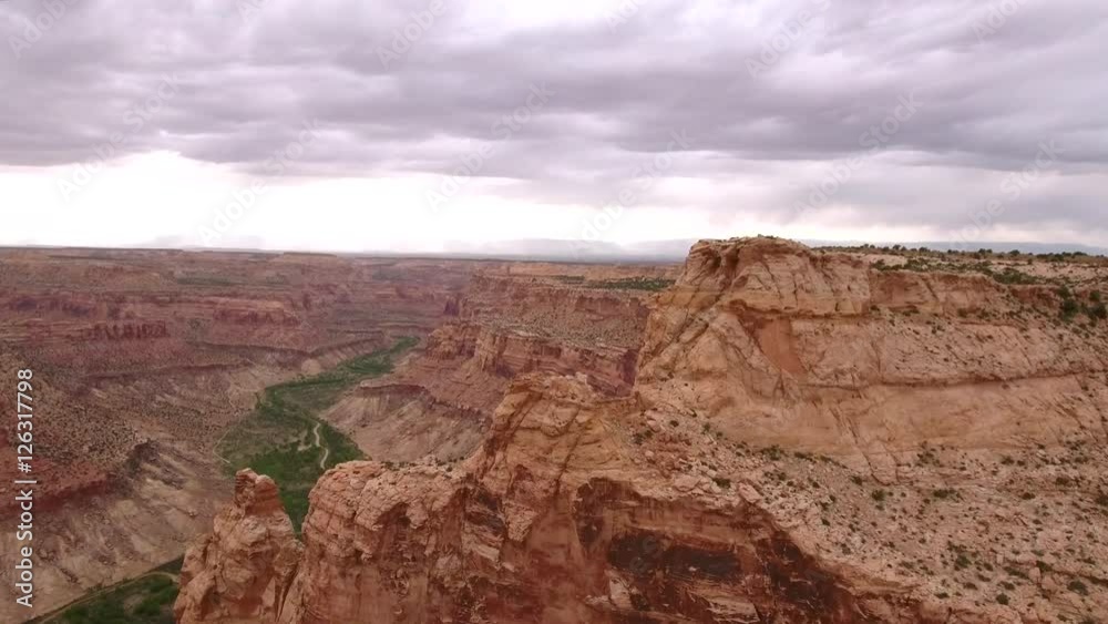 Aerial shot flying above tall red desert cliffs and buttes Aerial shot flying above tall red desert cliffs and buttes