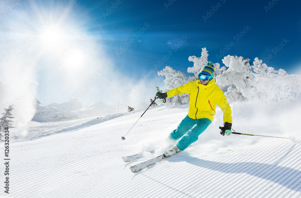Skier skiing downhill in high mountains