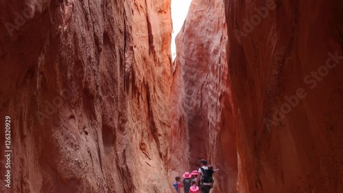 Family hikes gorgeous narrow slot canyon in the desert of Utah photo