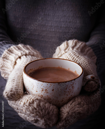 Woman in mittens holding a cup of hot chocolate