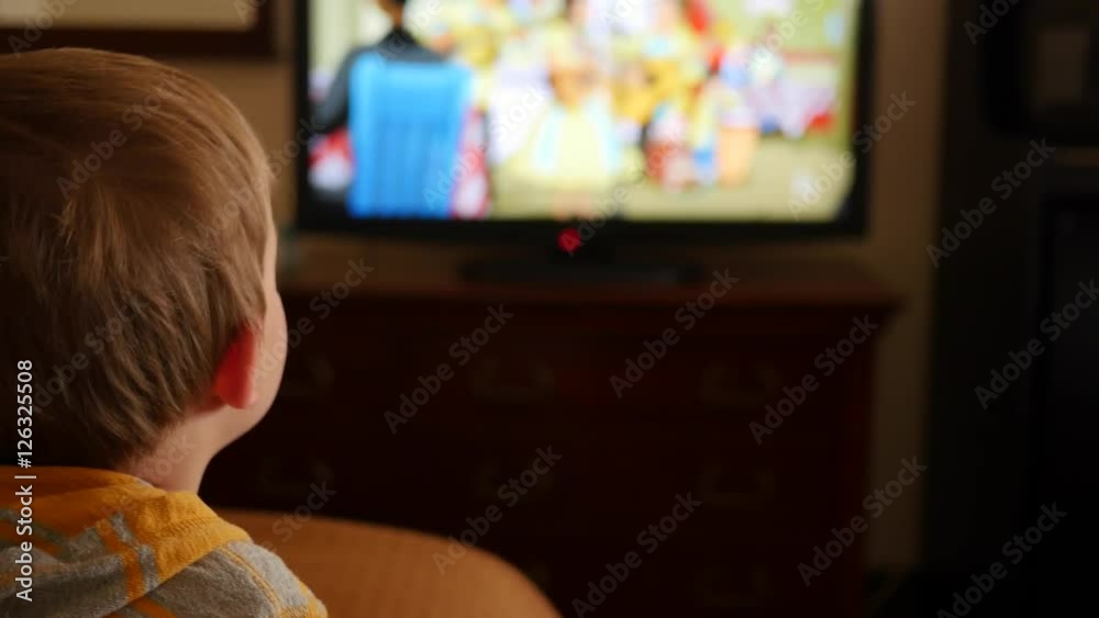 Little boy watches tv in hotel room dolly shot Little boy watches tv in hotel room dolly shot