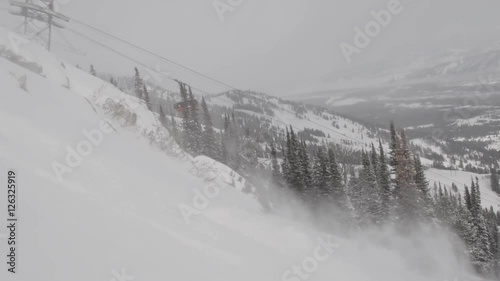 Man and woman ski powder at resort in Jackson Hole