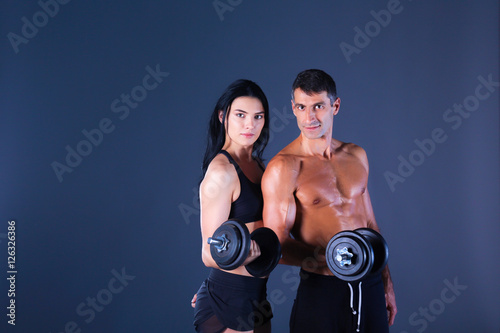 Athletic man and woman with a dumbells