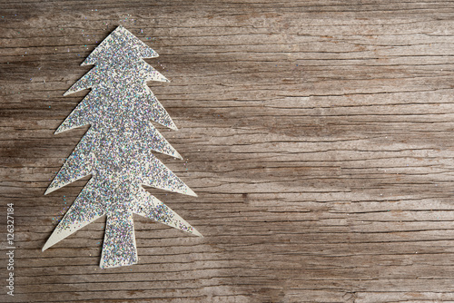 Paper Christmas tree and sequins on wooden background