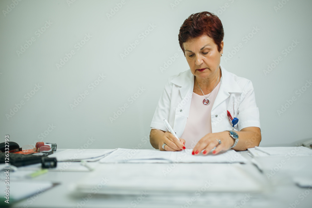 Taking care of your health concept. Experienced doctor prescribing medicines. Senior medical professional writing patients medical record. Retiring doctor.Retirement Taking care of your health concept. Experienced doctor prescribing medicines. Senior medical professional writing patients medical record. Retiring doctor.Retirement