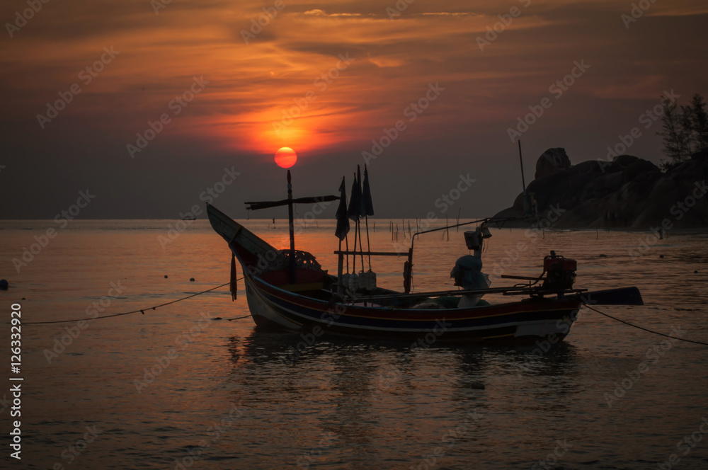 Silhouette fishing boat at sunrise time  on the beach