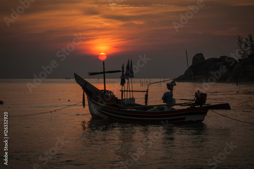 Silhouette fishing boat at sunrise time on the beach