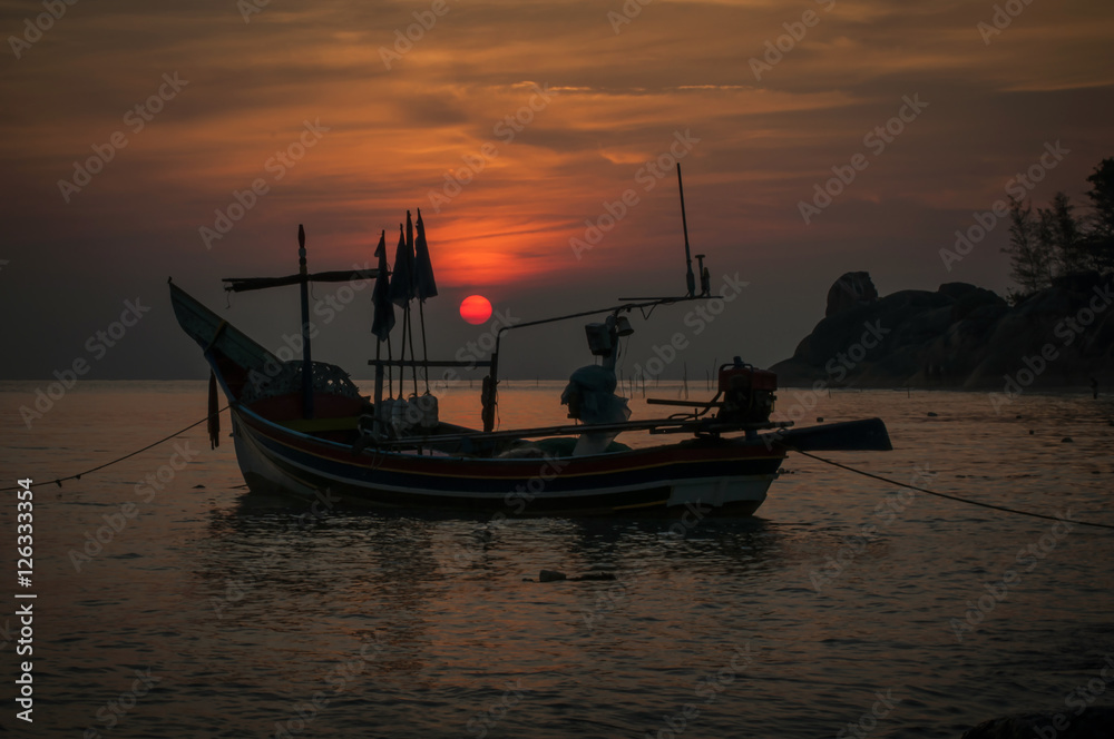 Silhouette fishing boat at sunrise time  on the beach