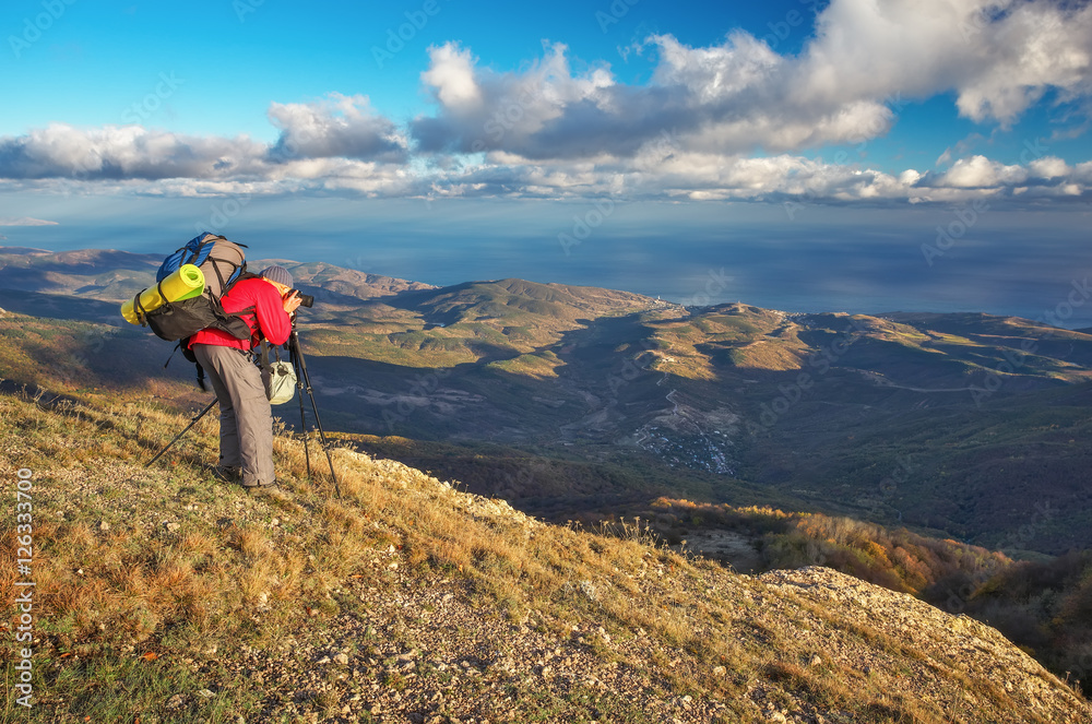 Photographer takes pictures on top of the mountain in autumn. 