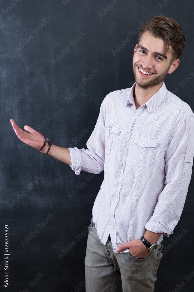 Portrait of young happy smiling teacher man standing near chalkb Portrait of young happy smiling teacher man standing near chalkb