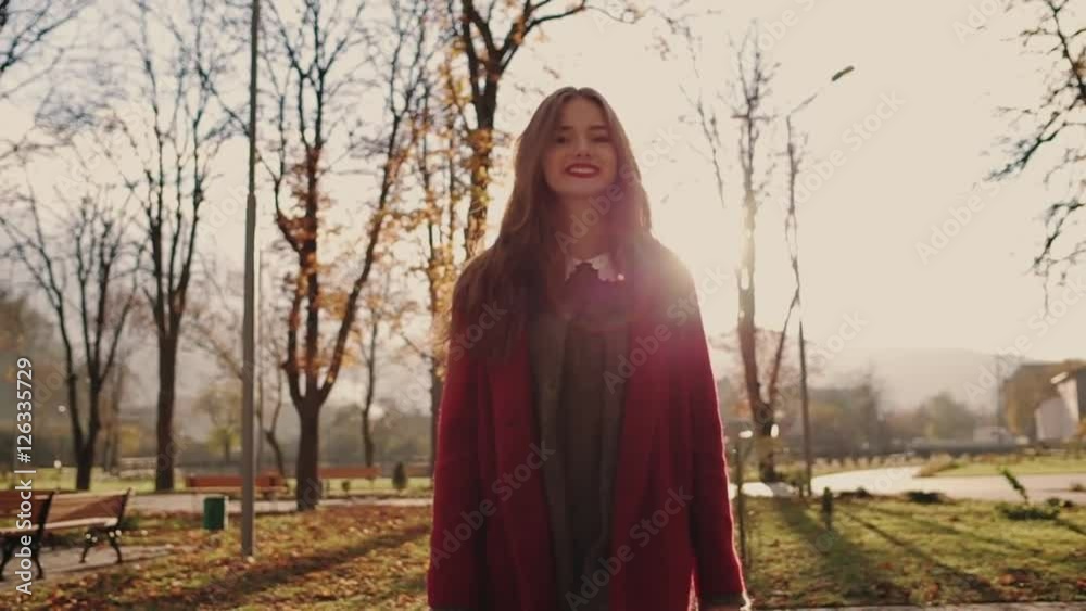 Business woman in red coat with coffee walking in the city and communicate via smart phone (phablet). Steady cam shot. Business woman in red coat with coffee walking in the city and communicate via smart phone (phablet). Steady cam shot.
