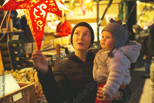 Happy family spend time at a Christmas street market and fair
