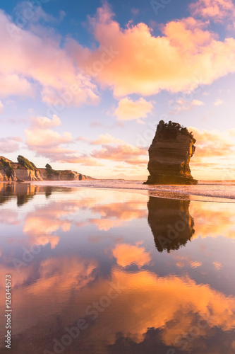 Lone rock on a sunset ocean coast photo