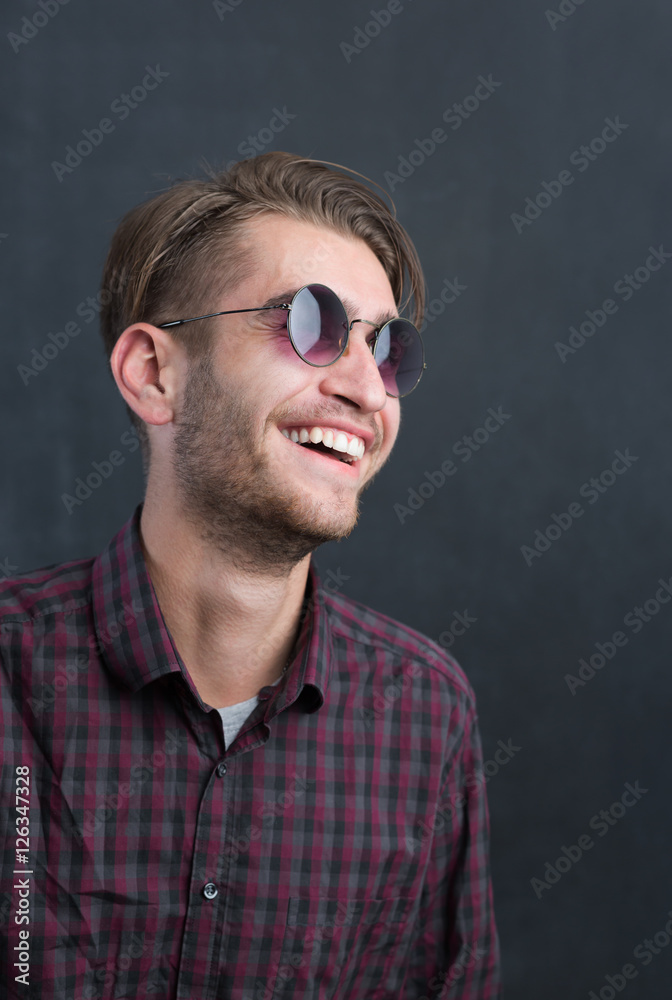 Portrait of a relaxed young man with checkered shirt and sunglas Portrait of a relaxed young man with checkered shirt and sunglas