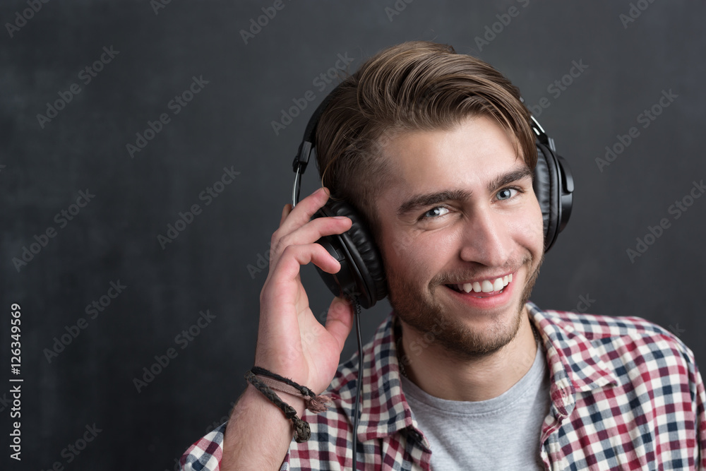 Portrait of confident young DJ with stylish haircut and headphon
